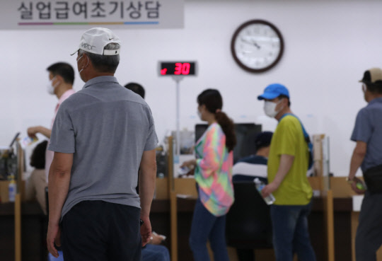 10일 서울 중구 서울고용복지플러스센터를 찾은 한 구직자가 실업급여설명회장에 들어가기 위해 줄 지어 선 사람들을 바라보고 있다.   연합뉴스
